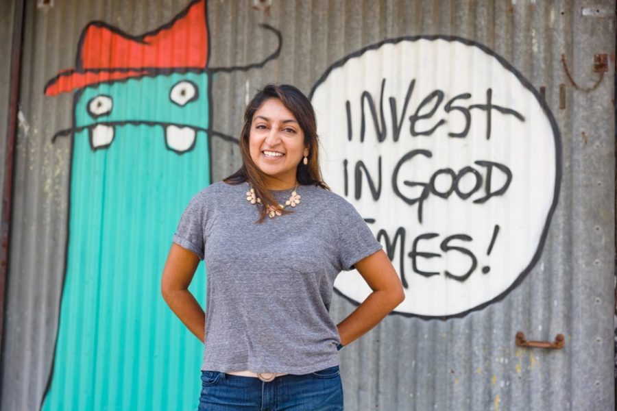 Jani in front of a mural that reads Invest in Good Times